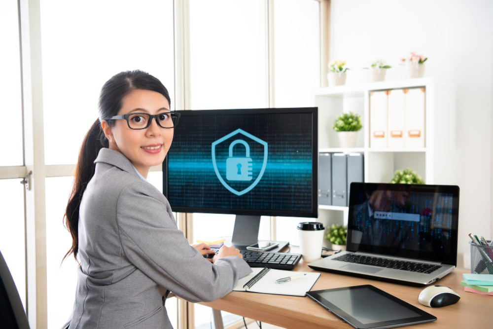 A woman is sitting at a desk with a laptop and a padlock on it.